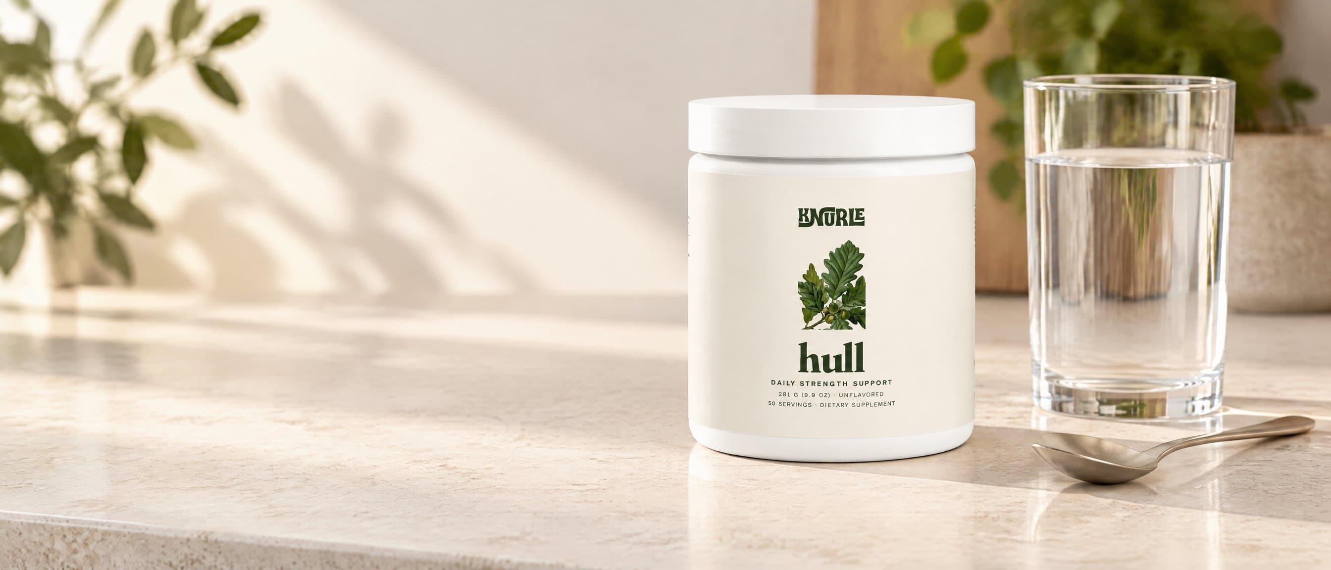 A tub of Hull on a stone kitchen counter beside a glass of water and a spoon