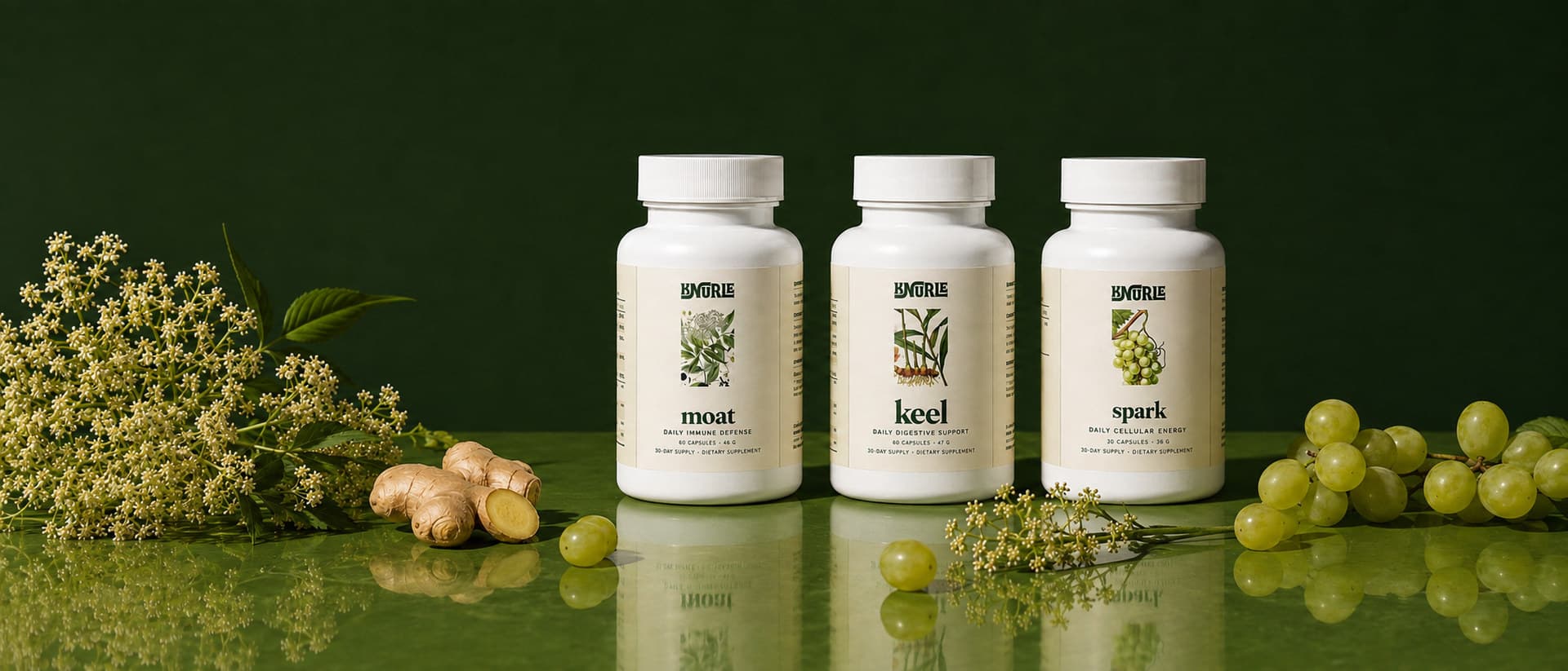 Moat, Keel and Spark on a green table with elderflower, ginger and grapes