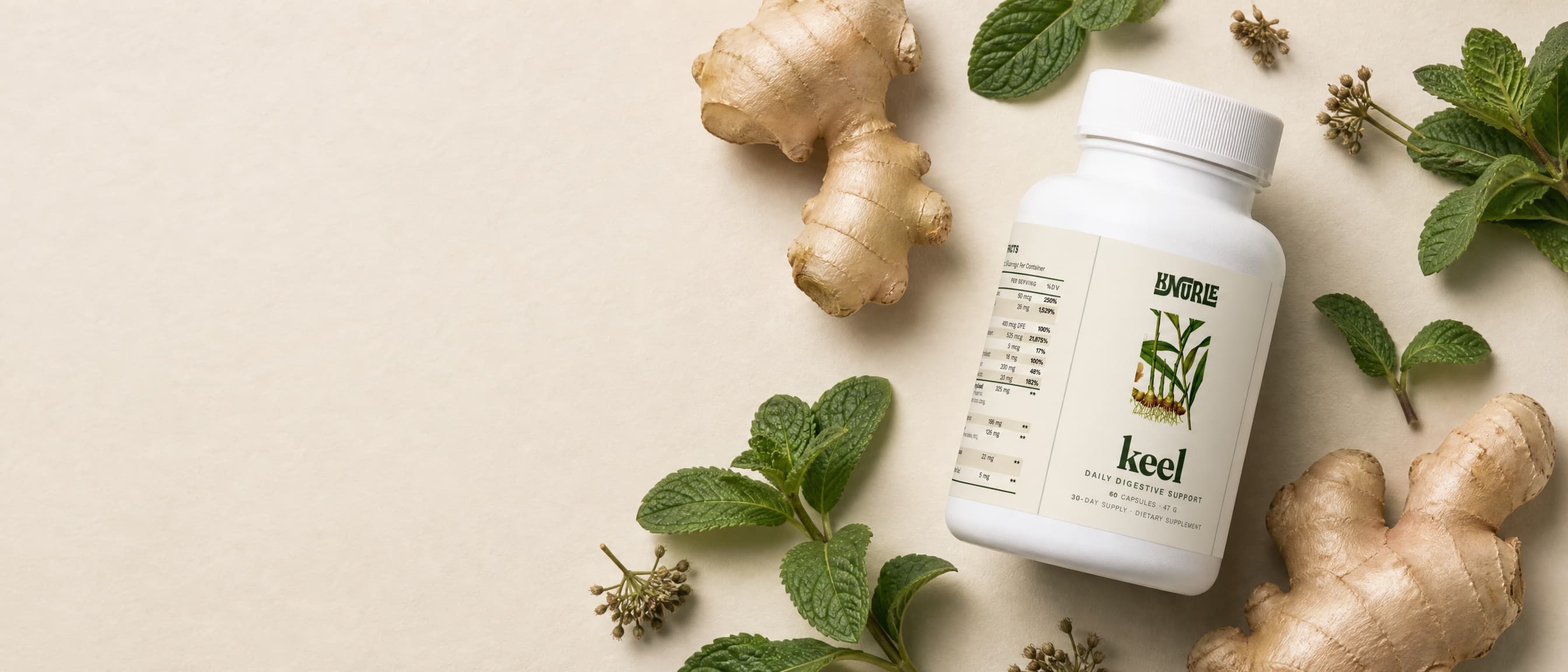 A bottle of Keel photographed from above among fresh ginger root and peppermint